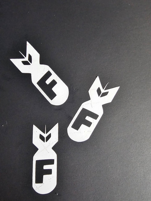 Three white F-bomb vinyl decals displayed on a black background