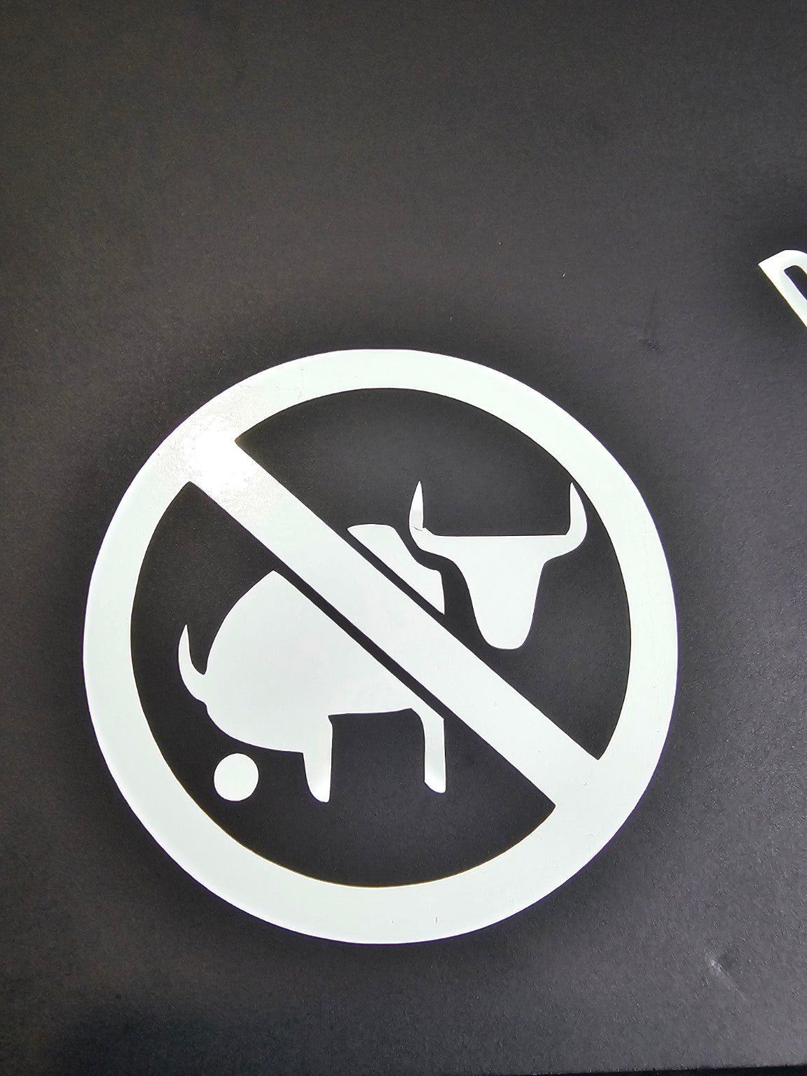 White No Bullshit prohibition-symbol vinyl decal displayed on black board